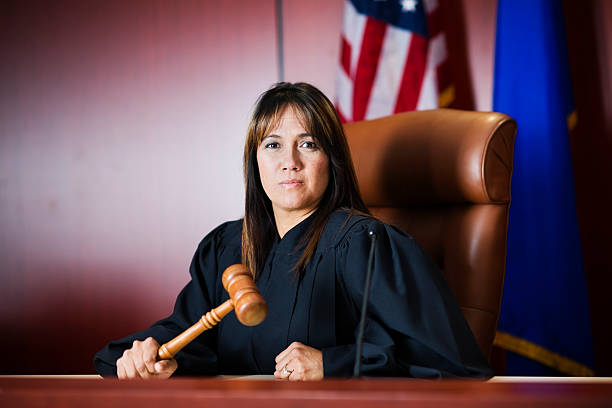 Female judge sitting in court holding her gavel stock photo