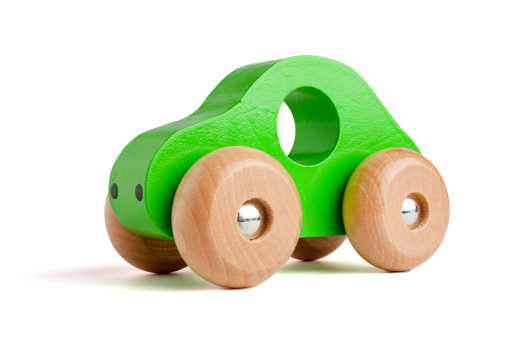 Green wooden toy car isolated on white.