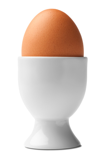 Brown chicken egg in a white egg cup isolated on white background with clipping path