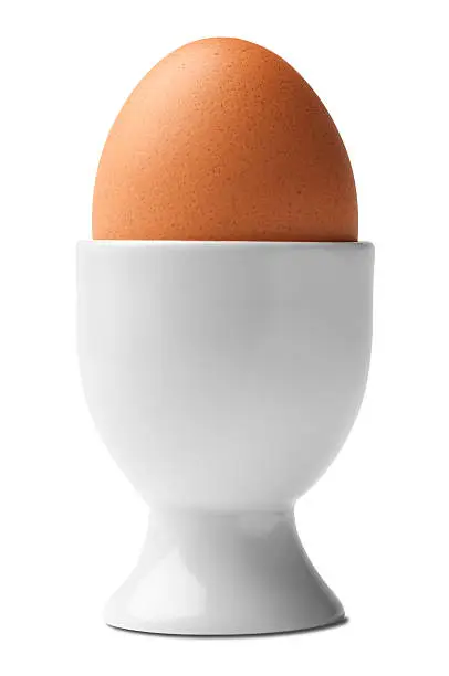 Photo of Hard boiled chicken egg in egg cup isolated on white