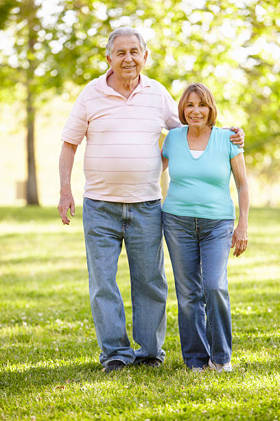 istock Senior Hispanic Couple Walking In Park 184402872
