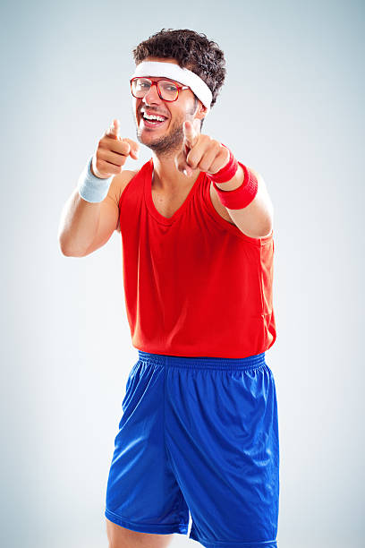 Happy fitness nerdy male is pointing his forefingers to you stock photo
