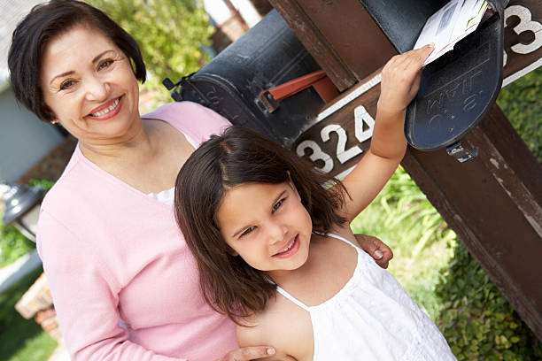istock Hispanic Grandmother And Granddaughter Checking Mailbox 184402929