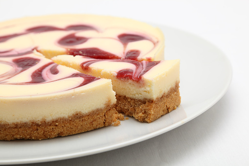 raspberry cheesecake on round plate plain background - soft shadows not isolated