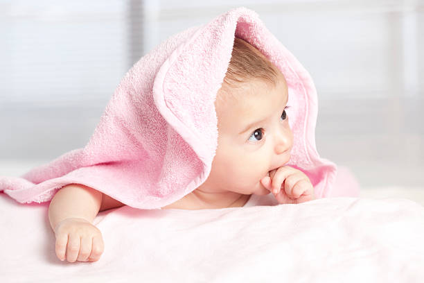 istock Lovely baby under pink towel. 184403559