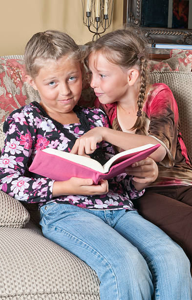 istock Young Girls Reading, Annoyed with Sister 184403728