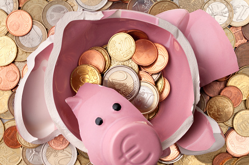 Savings. Broken piggy bank with euro coins.