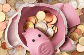 Savings. Broken piggy bank with euro coins