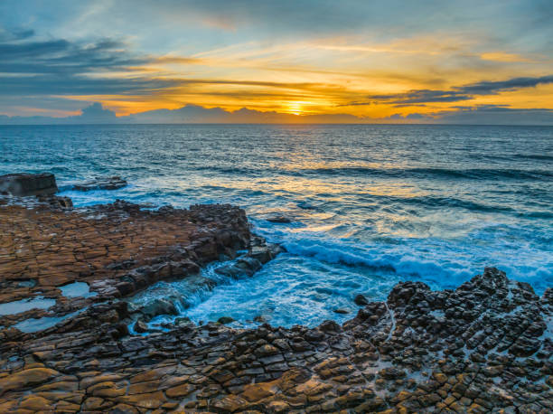 istock Sunrise over the sea and rock platform with high cloud 1844042743