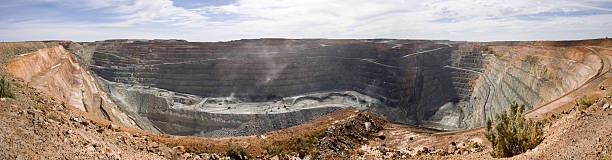 A huge mining superpit on a sunny day The Superpit is located in Kalgoorlie in central Western Australia.  The Superpit is Australia's largest open pit gold mine and one of the largest open pit mines in the world. gold mine photos stock pictures, royalty-free photos & images