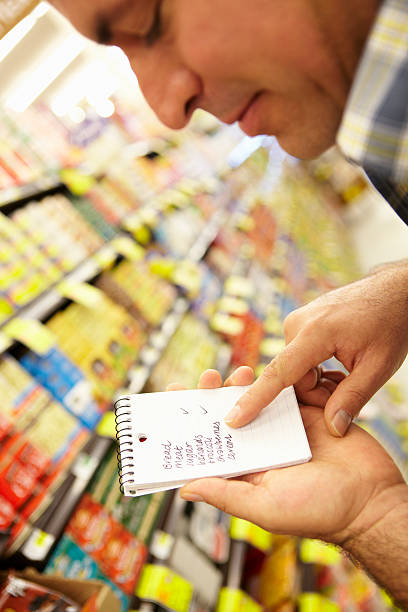 istock Man Looking At Shopping List In Supermarket 184404727