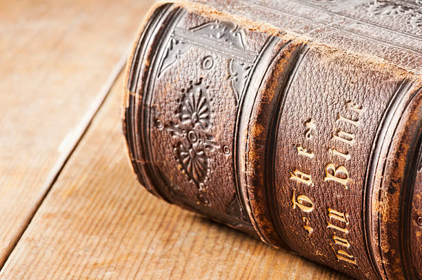 istock Leather Holy Bible with gold letters lying on wooden table 184405388