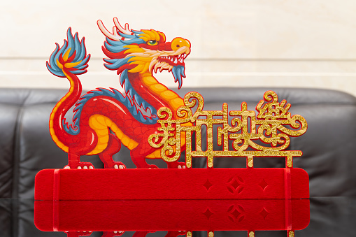 Chinese New Year of Dragon mascot paper cut in a living room English translation of the Chinese words is happy new year no logo no trademark