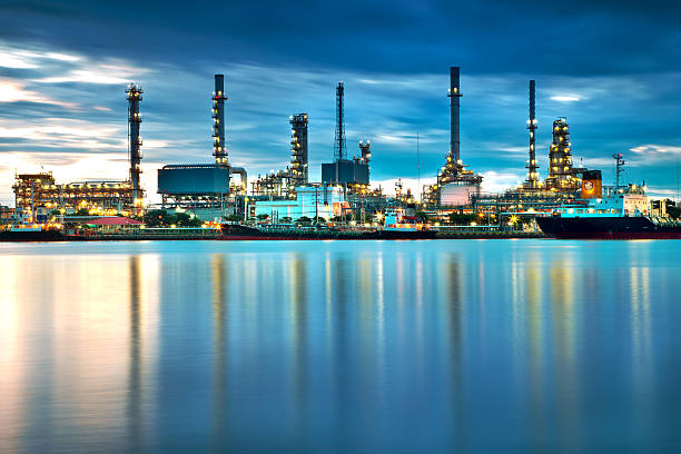 нефтеперерабатывающий завод с отражением, нефтехимический завод - distillation tower стоковые фото и изображения