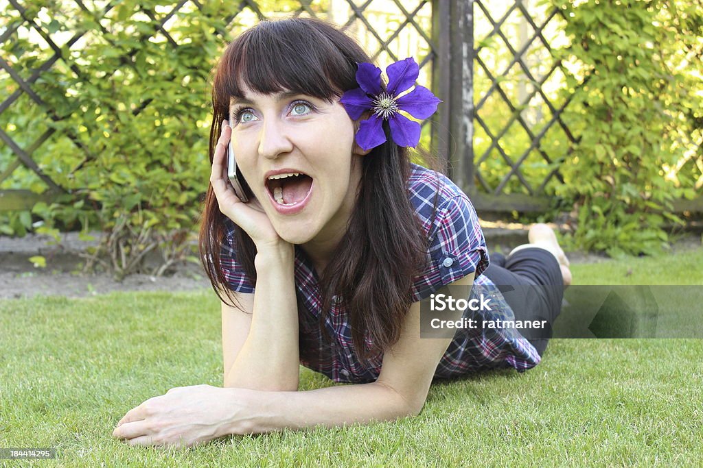 Femme souriante de téléphone portable dans le jardin ensoleillé - Photo de Adulte libre de droits