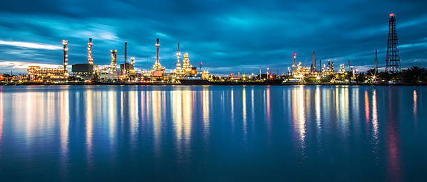 панорама нефтеперерабатывающий завод с отражением - distillation tower стоковые фото и изображения