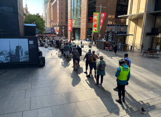 uma fila esperando para ser atendida na cozinha comunitária no martin place. - homelessness food in a row people - fotografias e filmes do acervo