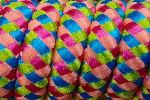 A close-up of a colorful array of colorful yarn braided together.