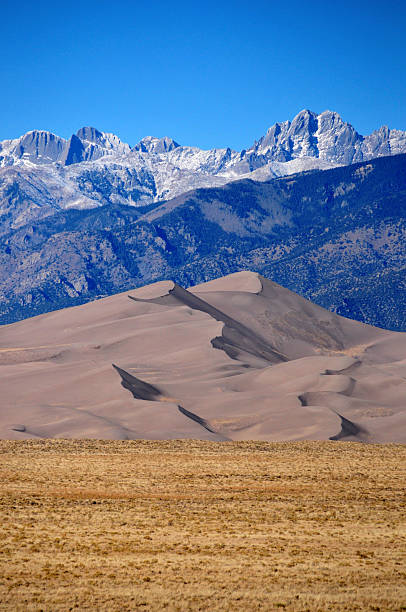 Great Sand Dunes NP: between plain and mountains Great Sand Dunes National Park, CO, USA: sand dunes between the plain of the San Luis Valley and the snow covered Sangre de Cristo Mountains - photo by M.Torres great sand dunes national park stock pictures, royalty-free photos & images
