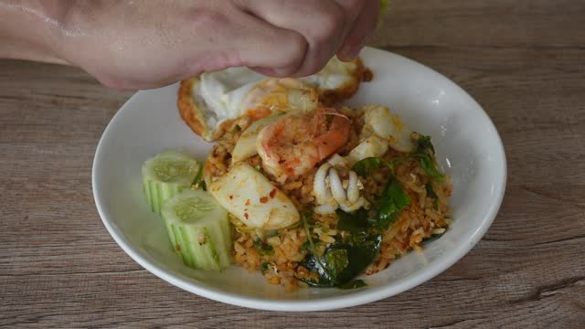 spicy fried rice seafood shrimp and squid in tom yum sauce  squeezing lemon for tasty