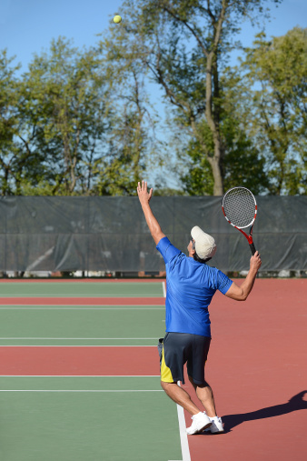Mature man playing tennis on court