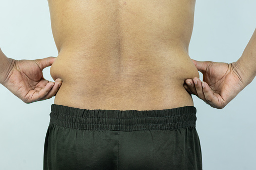 Man touching pot belly or belly fat. Close-up of body parts