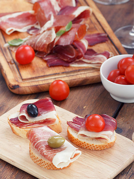 istock sliced prosciutto with olive cheese and Cherry tomato 184423400