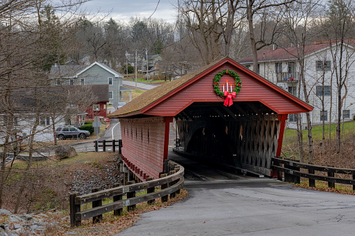 Historic timber one lane covered bridge in the Town of Newfield, Tompkins County NY with holiday lights.