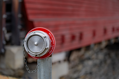 Close up of a fire department dry fire hydrant connection for a sprinkler system for a one lane timber bridge.