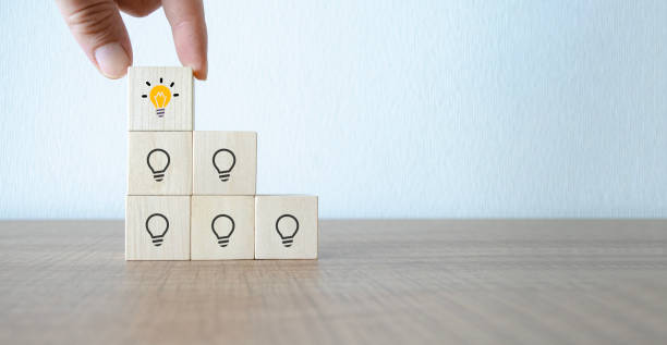 istock Concept creative idea and innovation. wooden cube block with head human symbol and light bulb icon 1844250273