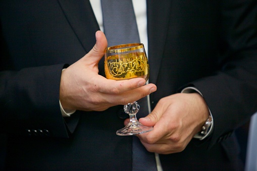 Men's hands with a glass of expensive cognac