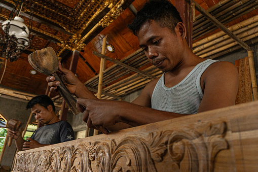 Wood carving craftsmen from Jepara are working on carvings for the construction of the mosque foyer on December 05, 2017  in Demak, Indonesia.