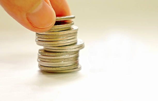 istock coins stacks with a hand picking up on white background 184429209