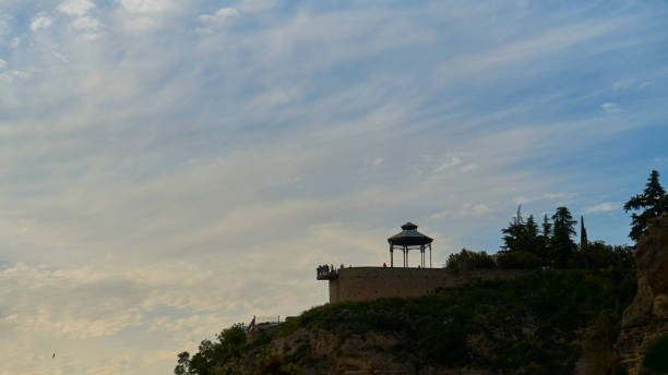 Silhouetted tourists admiring sunset in Ronda Spain