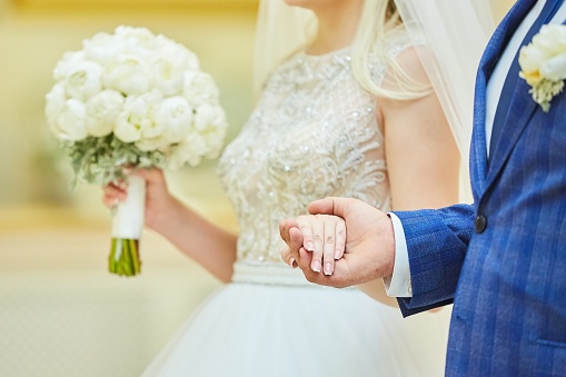 The hands of the bride and groom. Wedding ceremony or engagement celebration.