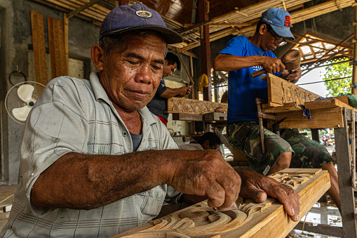 Wood carving craftsmen from Jepara are working on carvings for the construction of the mosque foyer on December 05, 2017  in Demak, Indonesia.