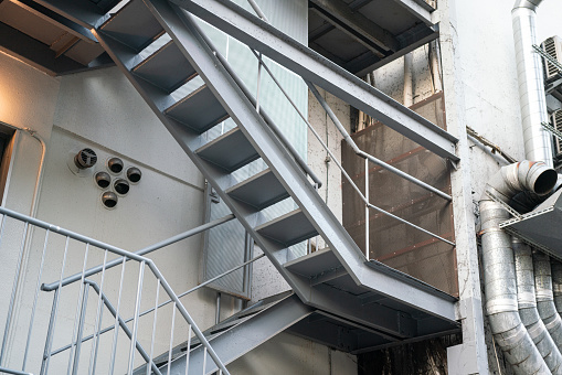Fire escape stairway outside the high rise building tower, using for the emergency escape route. Building structure and transportation object.