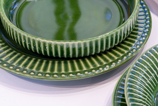 Ceramic tableware dishes plates on grunge green background