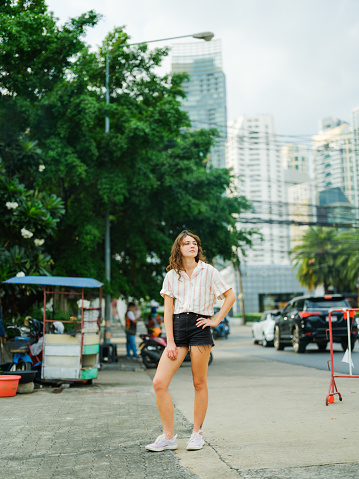 Woman walking in the city of Bangkok exploring its vibrant scene during her vacation