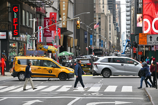 New York, USA - April 22, 2019:  Yellow taxi cabs speeding in Midtown Manhattan, New York City, United States.