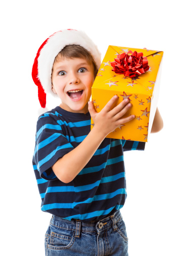 Smiling little boy in Santa's hat with yellow gift box, isolated on white