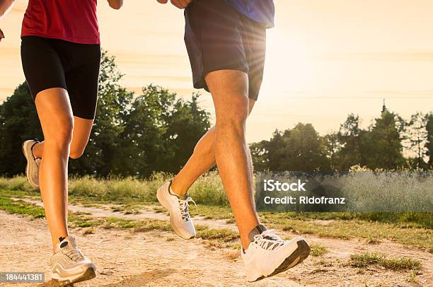 Pareja Joven Para Correr En Un Parque Foto de stock y más banco de imágenes de Calzado - Calzado, Correr, Atleta - Papel social