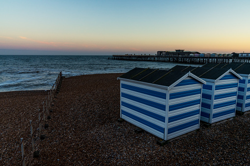 Hastings, East Sussex, England, UK - May 11, 2022: Evening mood on the beach, with some beach huts and the pier