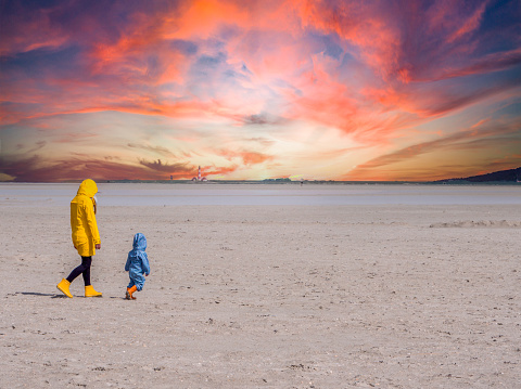 Woman is walking on the beach with her child