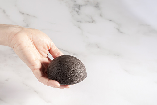 Konjac facial sponge in hand, beauty product for natural facial cleansing and care