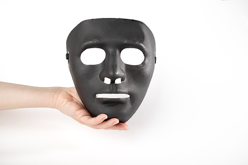 Drama festival, black mask in hand on white background, vintage costume, Masked identity, protection against cyber fraud