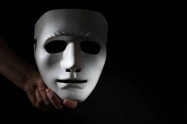 istock White mask in hand on a black background, Privacy protection, white mask concept, secure online identity 1844467646