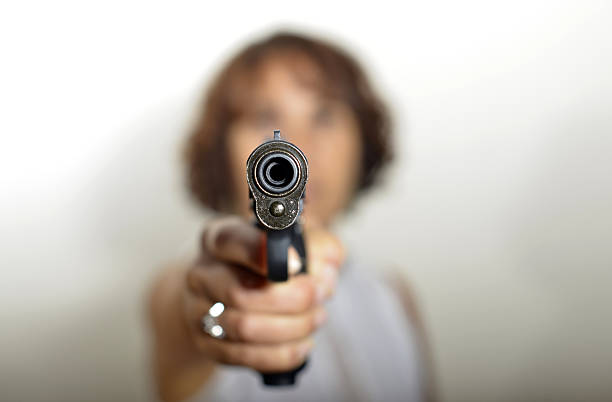 istock young woman with a firearm 184449142