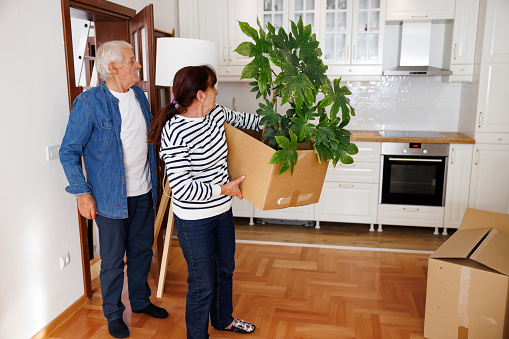 Side view of excited senior couple moving into new apartment