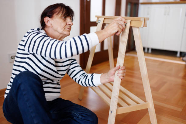 одна пожилая женщина собирает мебель в своей новой квартире - screw sitting on floor building activity working стоковые фото и изображения